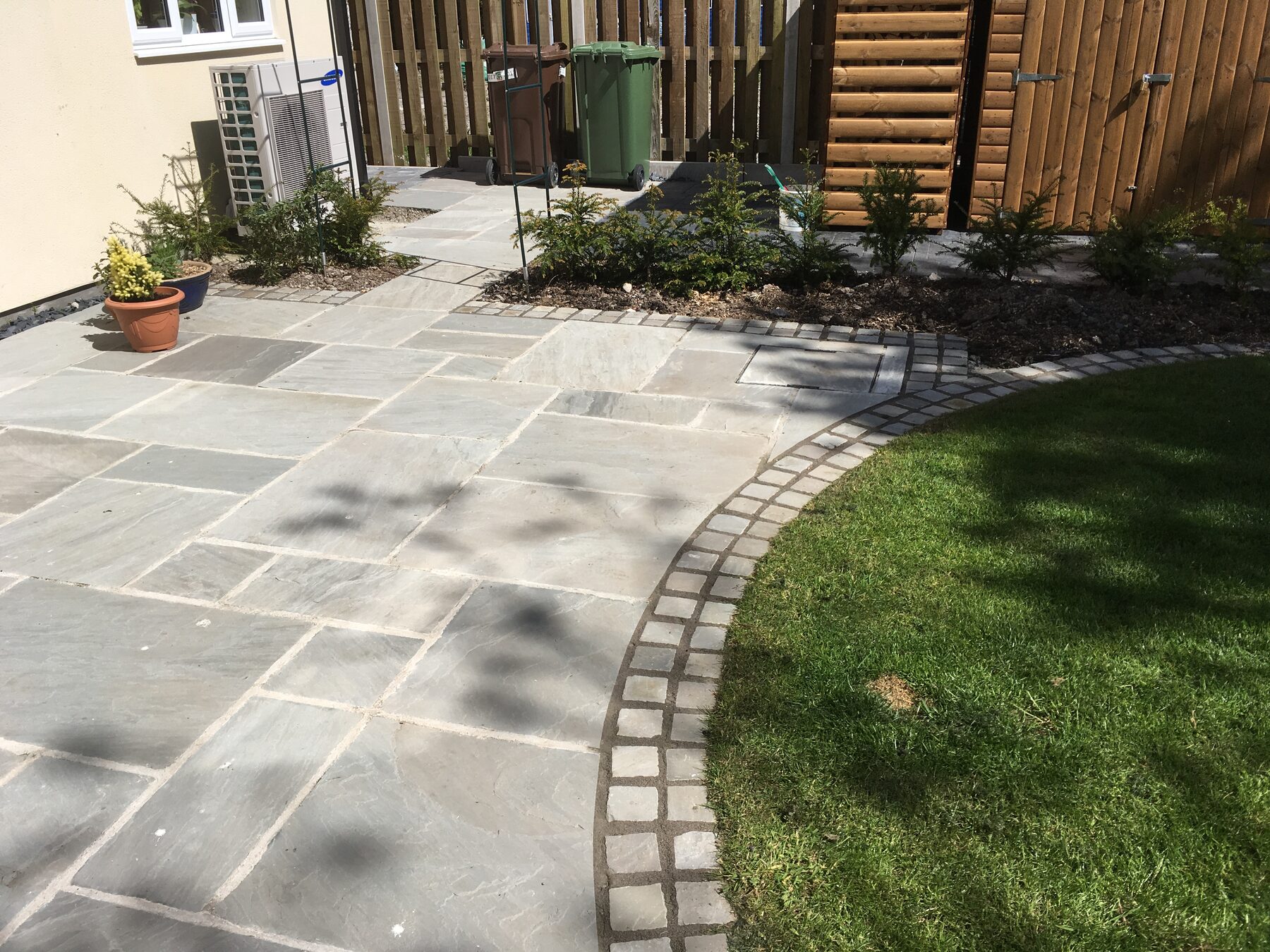 Finished natural stone patio with curved block edging